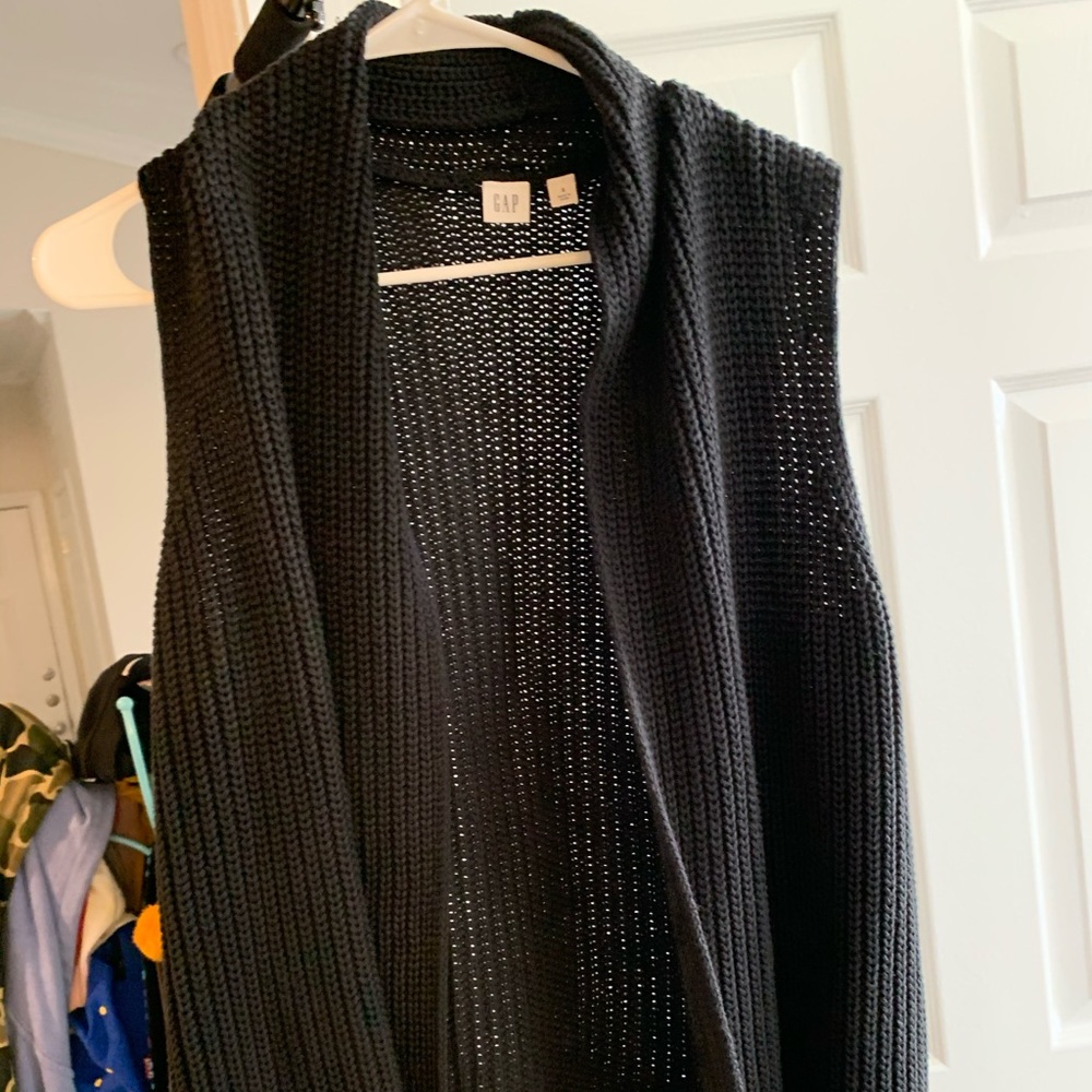 Black sleeveless cardigan.